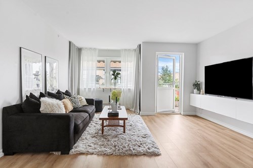 Tilltaget vardagsrum med utgång till balkong