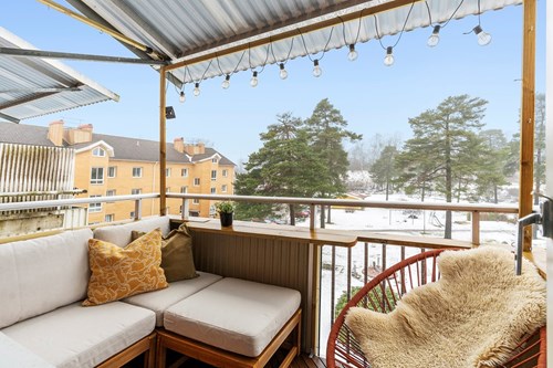 Balkong i västerläge med tak och utsikt över innergården.